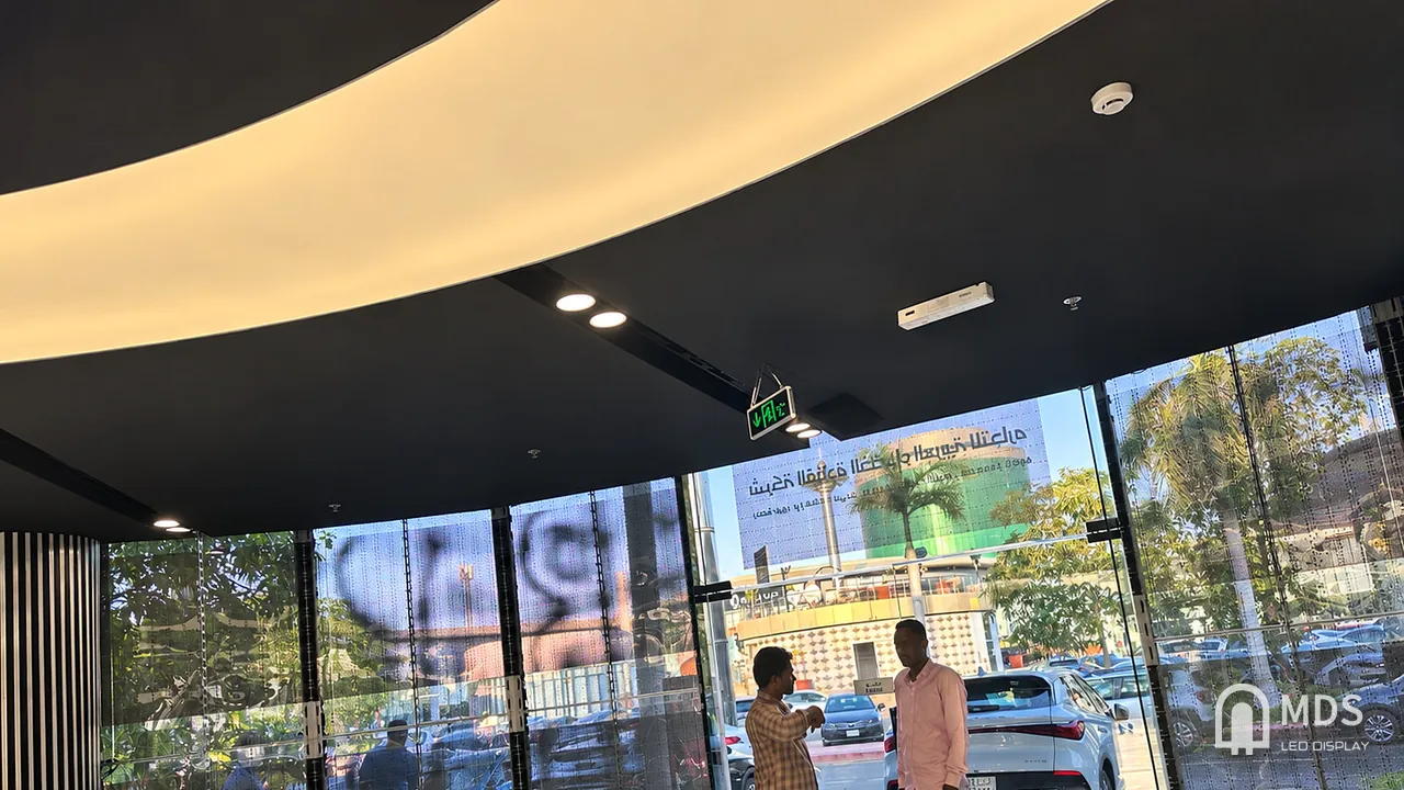 View from inside the BYD Jeddah showroom through the operating MDS transparent LED display toward the street