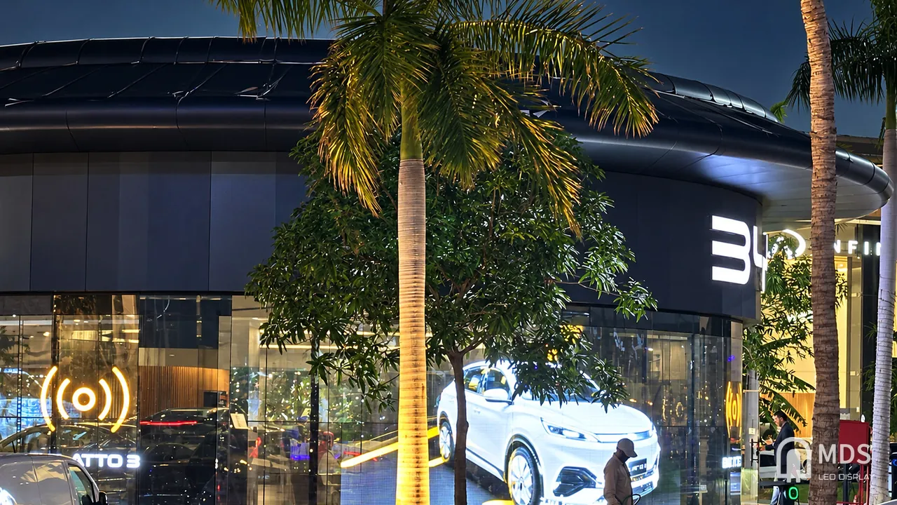 Side view of the MDS transparent LED display following the curved glass of the BYD showroom in Jeddah