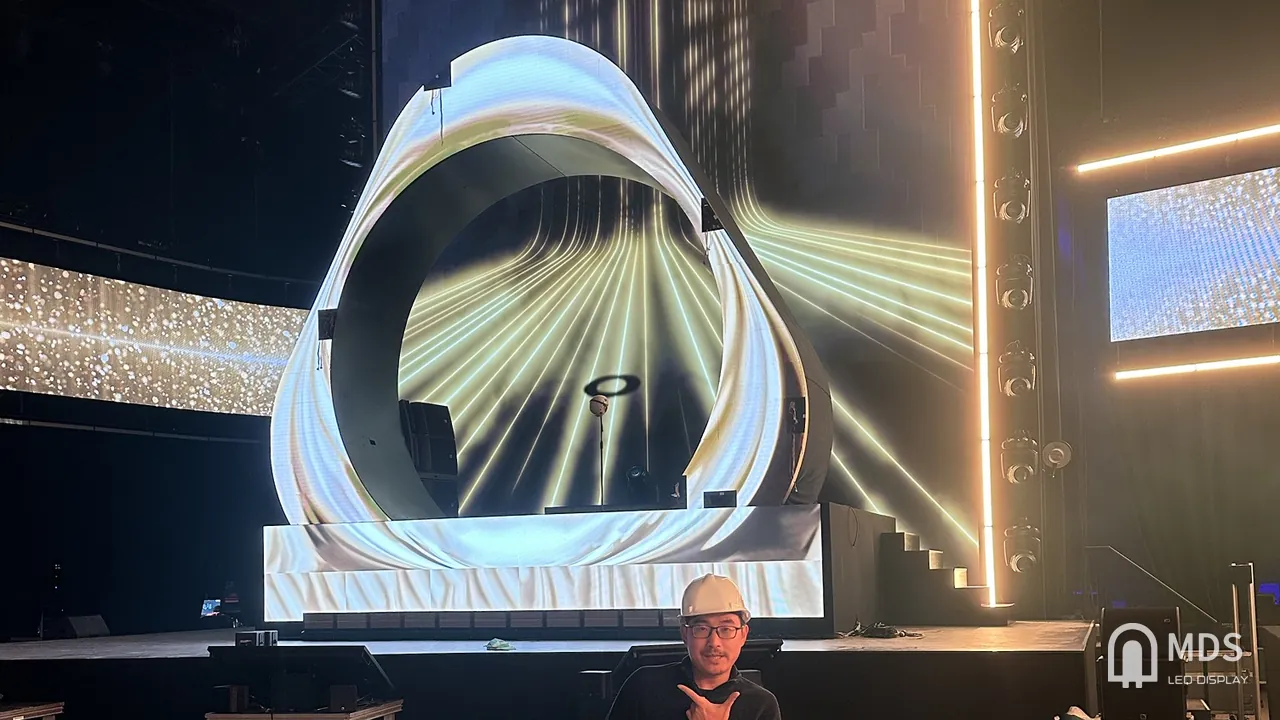 MDS engineer on site in front of the curved P1.56 LED ring and LED backdrop on the IQOS event stage in Milan, Italy