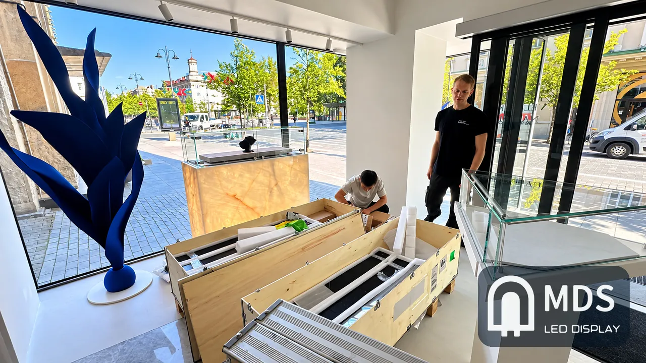 MDS engineer and local installers unpacking the transparent LED display panels inside the MARRYME by Ribas store in Vilnius