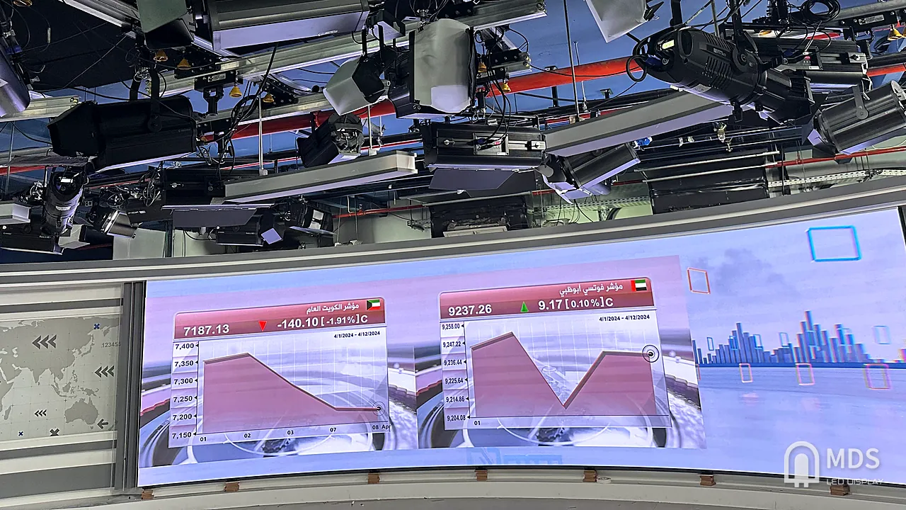 The curved fine-pitch LED wall in the CNBC Arabia studio showing Gulf market data, with the studio lighting rig above